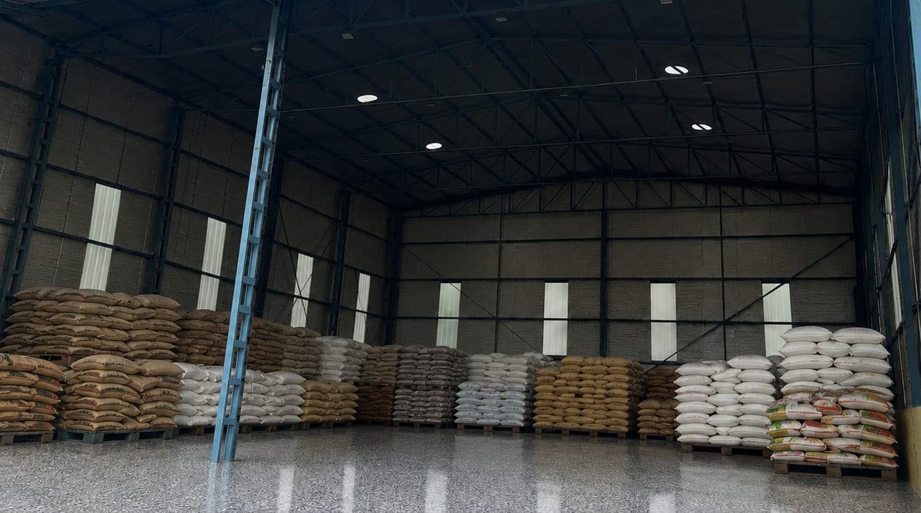 Raw botanical material stored in sacks on pallets in a warehouse